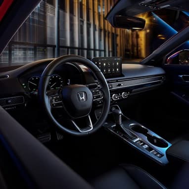2027 Honda Civic Sedan Sport Touring Hybrid dashboard and center console view at night (Compact Sedan)